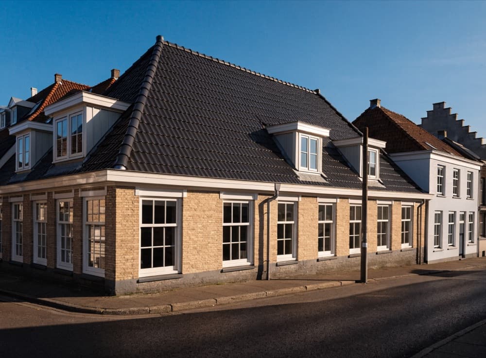 Afgewerkt nieuw pannendak op een rijtjeshuis, gezien vanaf de straat