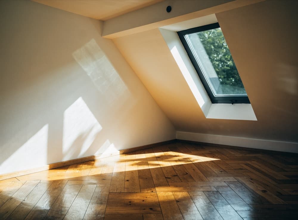 Zolderkamer met daglicht door een groot dakraam in het schuine plafond