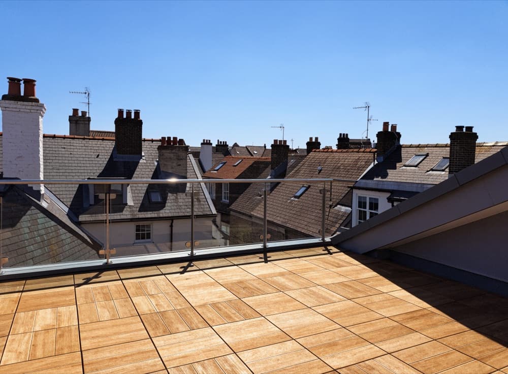 Dakterras met houten vlondertegels en een slanke metalen balustrade